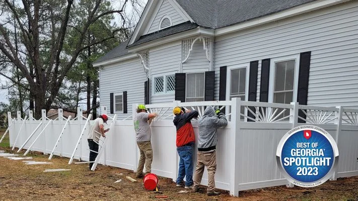 An aluminum fence panel installed along a sloped yard near a water feature in Warner Robins, Georgia, showing rust-resistant construction and clean black finish.