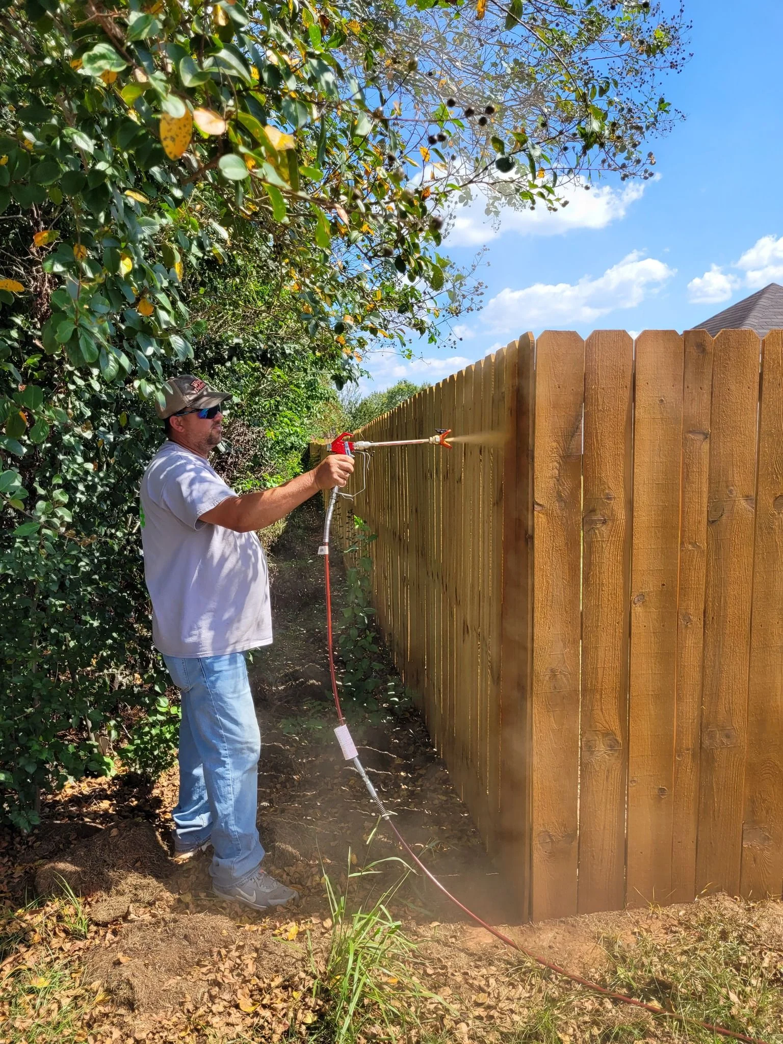 A freshly stained wood privacy fence in a residential backyard in Warner Robins, Georgia, showing even color and clean board surfaces after professional staining service by Lock Out Fence LLC.